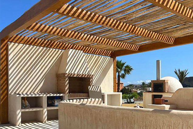 Pérgola de madera y varas de eucalipto para comedor exterior mediterráneo	