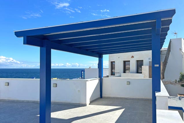 Pérgola de madera azul y blanca para azotea frente al mar